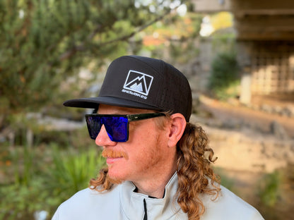 Rider wearing a black MTN.TOP snowbike wheelie snapback hat outdoors